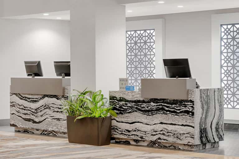 Hotel check-in desk with marble wave pattern and modern geometric wall panels