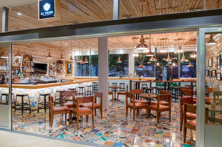 El Tigre restaurant interior with wooden ceiling, colorful tile floor, and bar counter