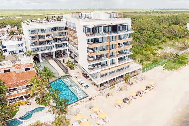 Beachfront hotel with modern architecture, pool, and sandy coastline