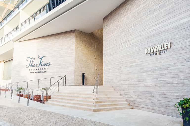Entrance to The Tres Oceanfront and Romarley Beachhouse with white brick walls and stairs