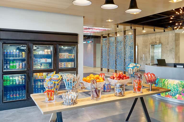Modern hotel market with refrigerated beverage cases, snacks, and fresh fruit display