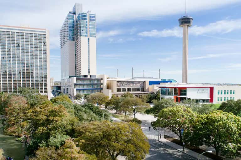 Urban cityscape with tall buildings, observation tower, and green park area