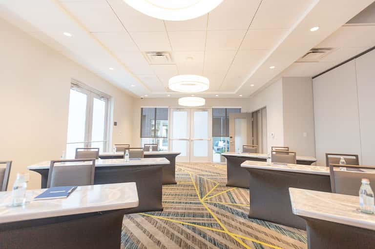 Modern hotel conference room with multiple desks and bright ceiling lights