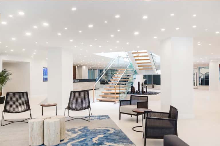 Bright modern lobby with staircase, contemporary seating, and minimalist design