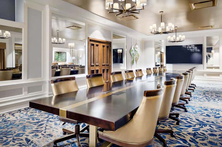 Elegant conference room with long dark table, cream chairs, and modern lighting