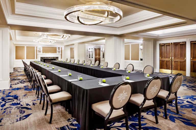 Elegant hotel conference room with long black table and cream-colored chairs