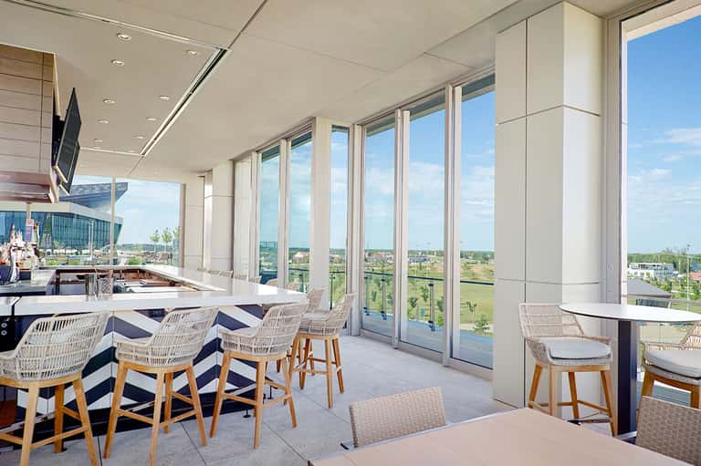 Contemporary restaurant interior with floor-to-ceiling windows overlooking scenic landscape and blue sky