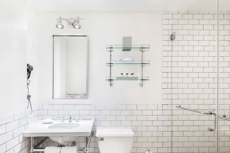 Modern bathroom with white subway tile, vessel sink, large mirror, and glass-enclosed shower