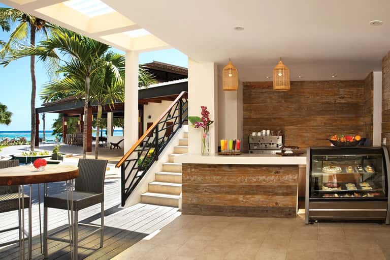 Modern beachfront bar and lounge with fireplace, ocean view, and wooden accents