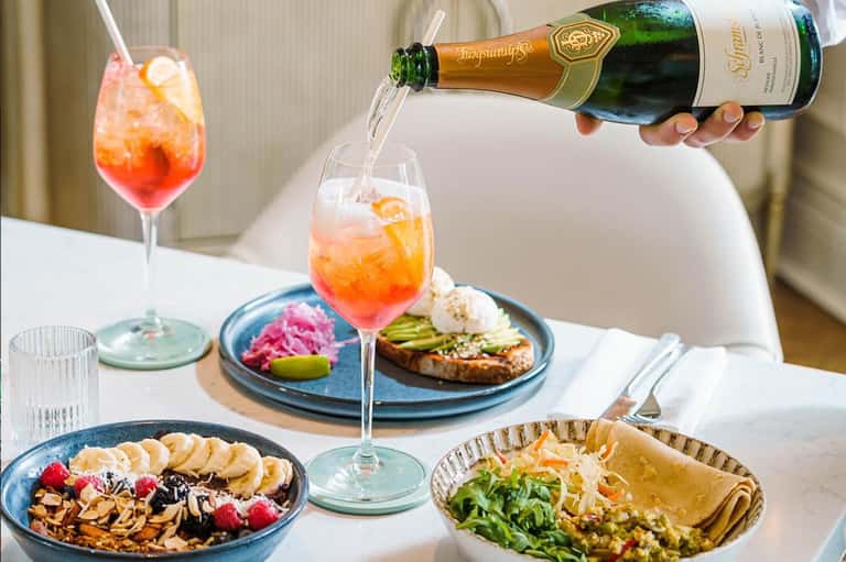 Champagne and colorful appetizers on white dining table