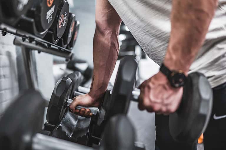 Man lifting dumbbells during strength training workout at gym facility