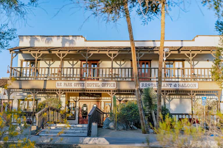 Rustic Western-style hotel building with wooden porches and signage for park office and restaurant