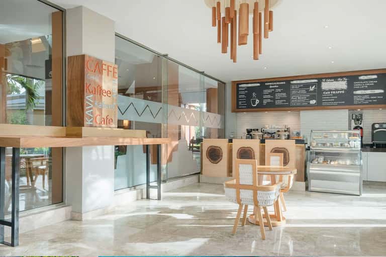 Modern cafe interior with wooden accents, glass partitions, and menu board