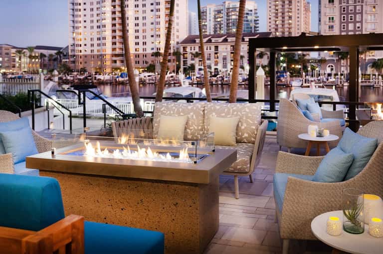 Waterfront lounge area with fireplace, comfortable seating, and evening ambiance
