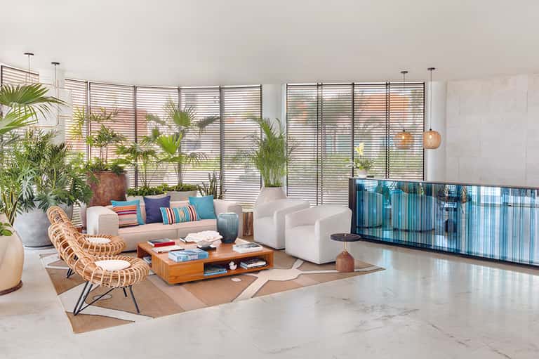 Contemporary penthouse living room with white sofas, plants, and panoramic ocean views