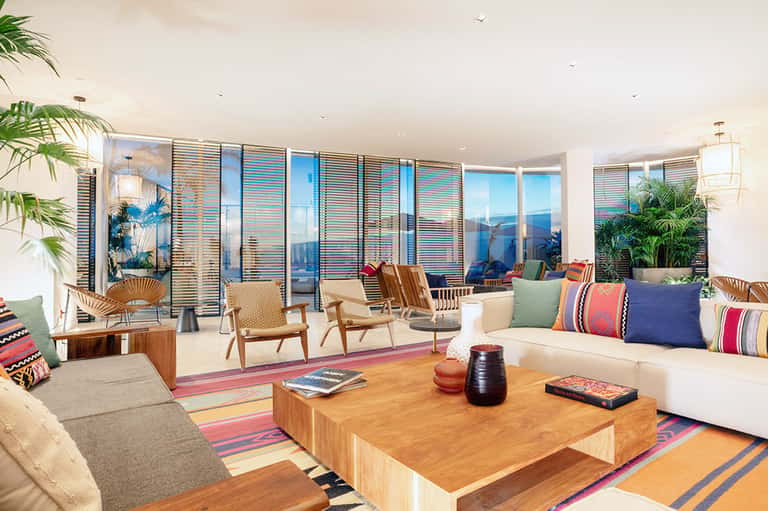 Modern living room with panoramic windows, contemporary furniture, and colorful striped accents