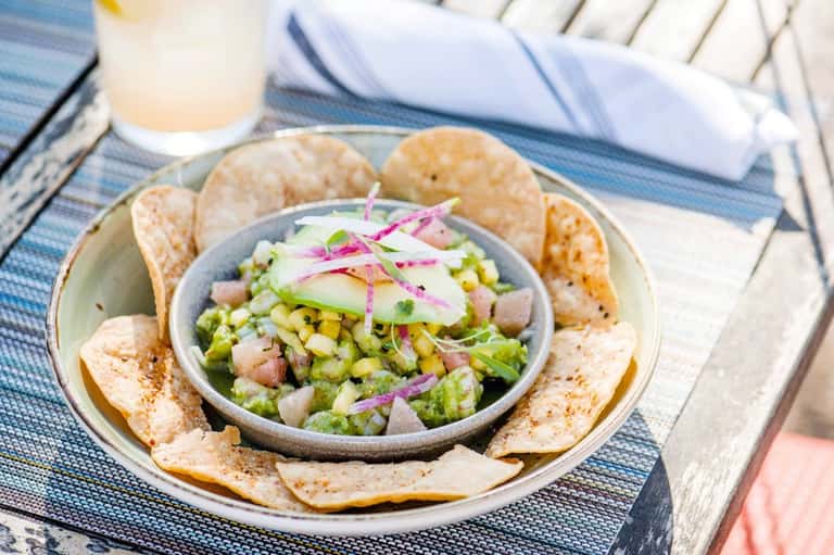 Ceviche appetizer with shrimp, corn, and pink onions served with crispy tortilla chips