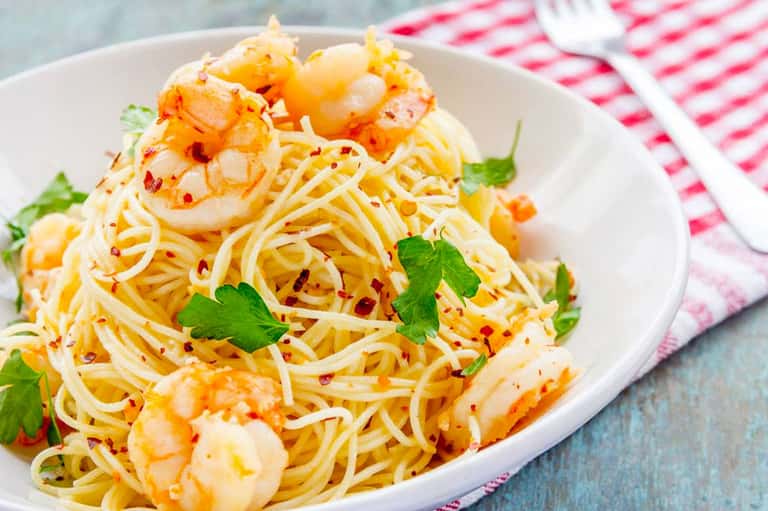 Shrimp scampi pasta with garlic and red pepper flakes garnished with fresh parsley