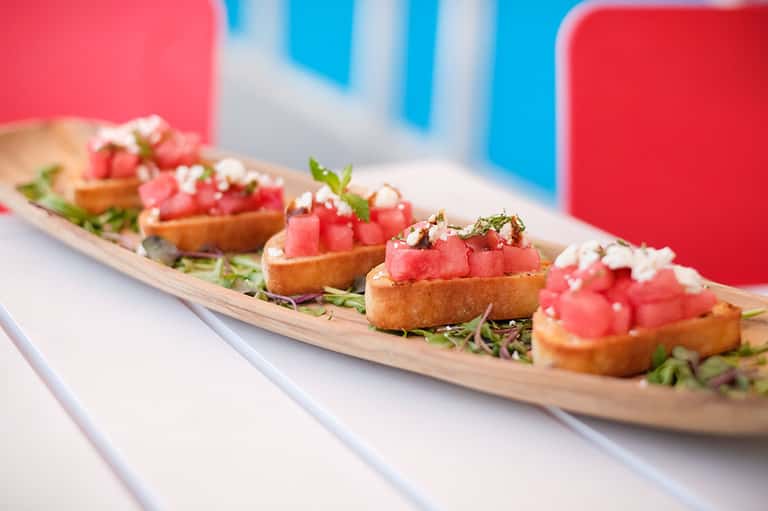 Gourmet appetizers featuring tuna tartare on crispy toast with microgreens and white sauce