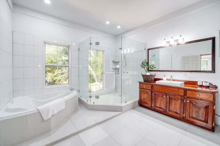 Luxury master bathroom with soaking tub, walk-in shower, and wooden vanity
