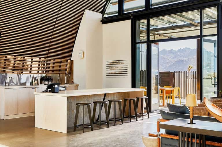 Modern kitchen and lounge area with mountain views, bar seating, and contemporary design