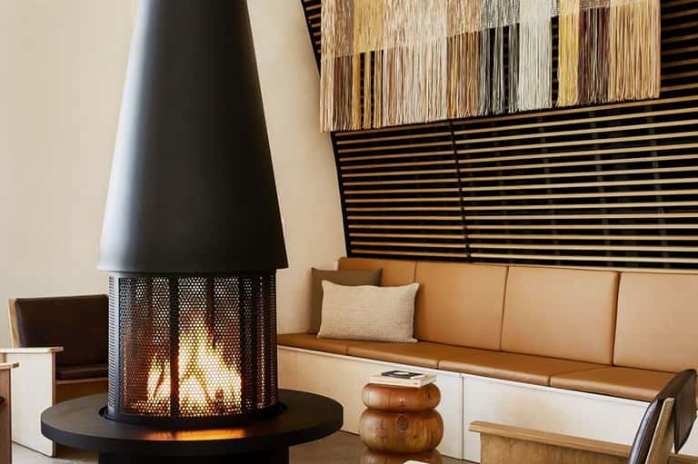 Modern lounge with fireplace, geometric wall art, tan leather sofa, and contemporary furnishings