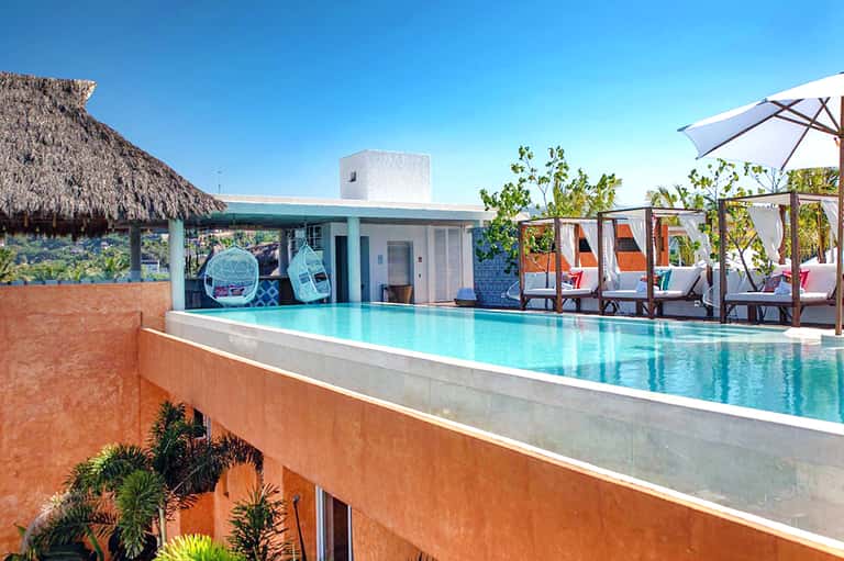 Modern rooftop infinity pool with turquoise water, loungers, and ocean view