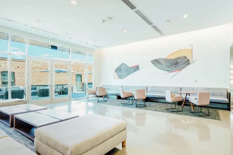 Modern resort lobby with ocean-view windows, contemporary seating, and coastal artwork