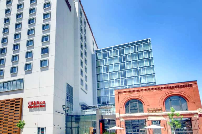 Modern hotel building exterior with Hilton sign, brick building, and contemporary architecture on clear day