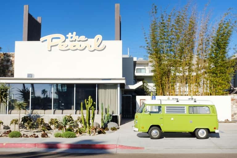 The Pearl hotel storefront with vintage lime green VW bus parked outside