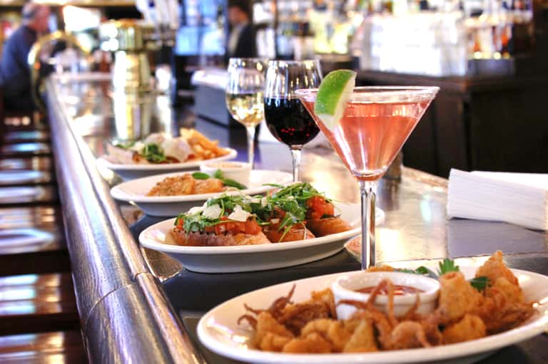 Fine dining restaurant with plated appetizers, wine, and cocktails at counter