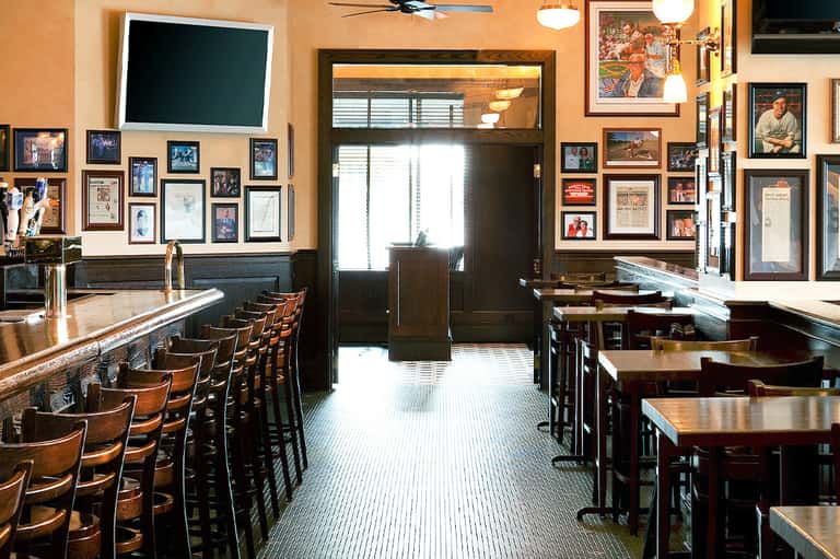 Classic bar interior with wooden seating, framed photographs, and vintage decor throughout