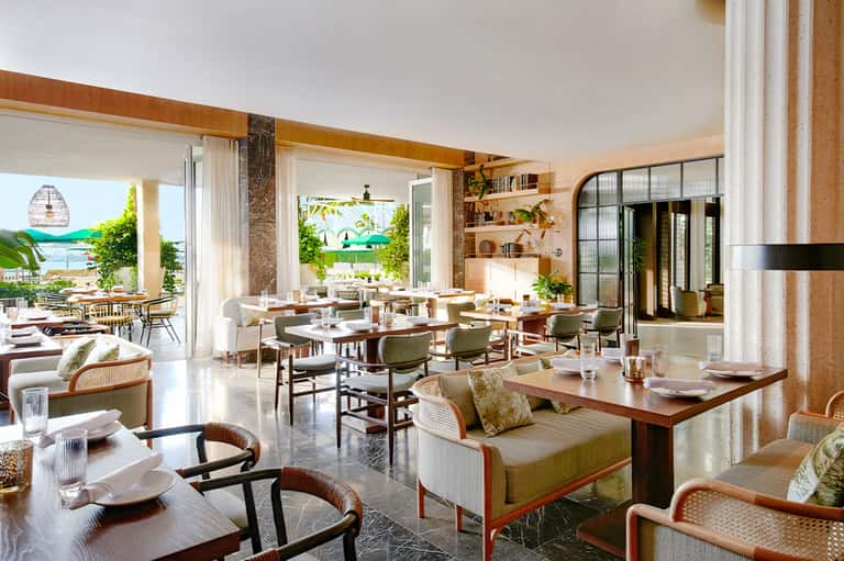 Modern beachfront restaurant with open-concept dining, ocean views, and natural wood accents