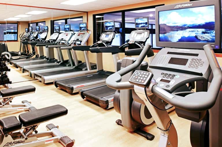 Fitness center with rows of treadmills and exercise equipment