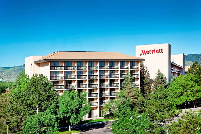 Marriott hotel exterior surrounded by lush green landscaping with mountains in background