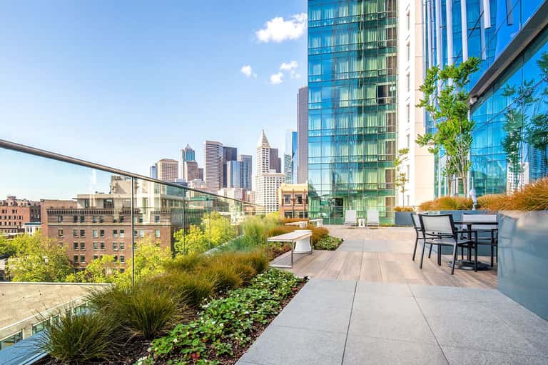 Modern rooftop terrace with city skyline views, contemporary seating, and landscaped gardens