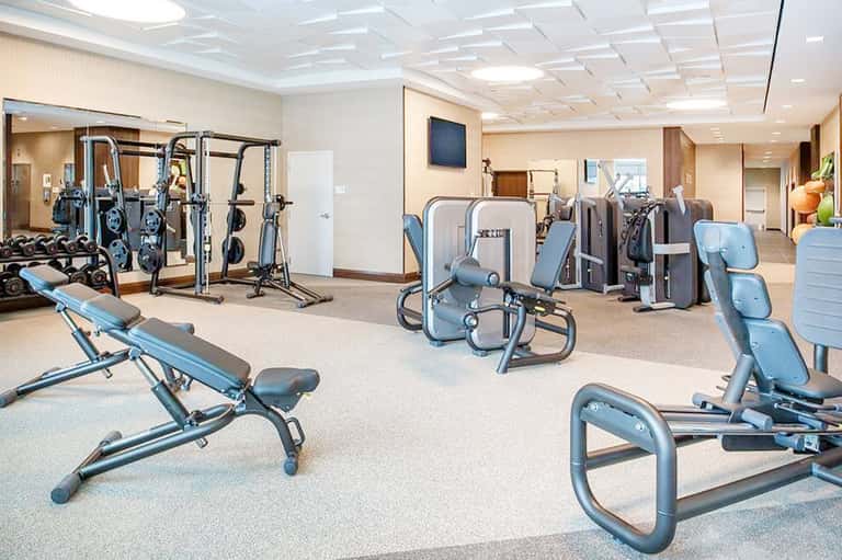 Fitness center with exercise equipment including bikes, weights, and strength machines