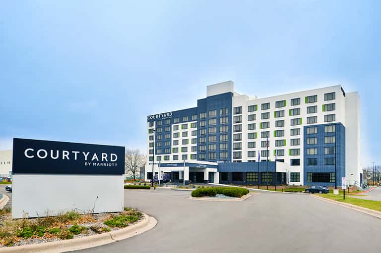 Modern Courtyard by Marriott hotel building exterior with blue and white facade in daytime