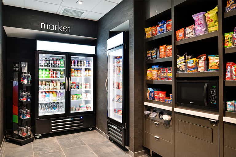 Hotel market snack area with refrigerated beverage coolers and shelves of packaged snacks