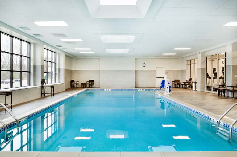 Indoor lap pool with lane markings, natural lighting, and modern facility architecture
