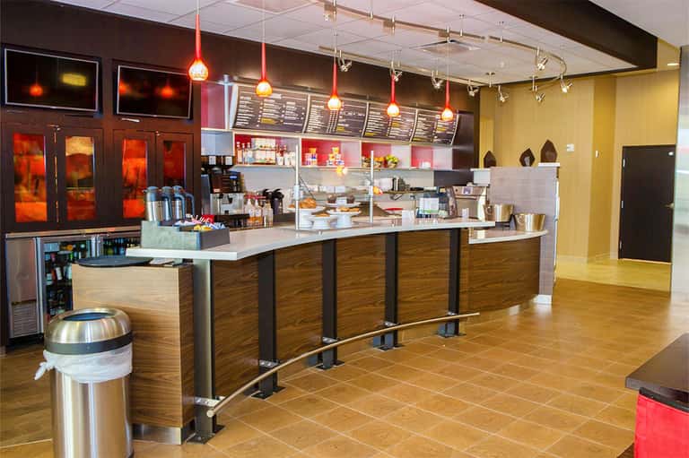 Modern coffee shop interior with wood counter, red pendant lights, and menu boards