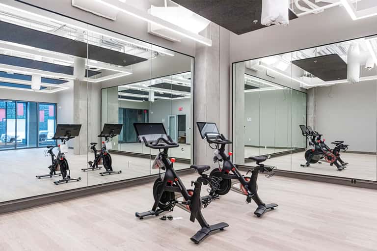 Modern fitness studio with stationary bikes and mirrored walls reflecting exercise equipment