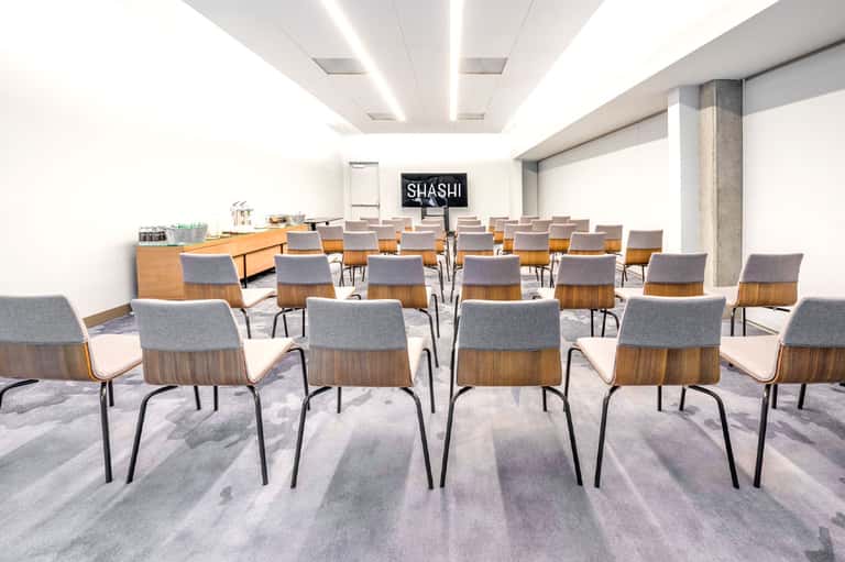 Modern conference room with wooden chairs and glass refreshment station