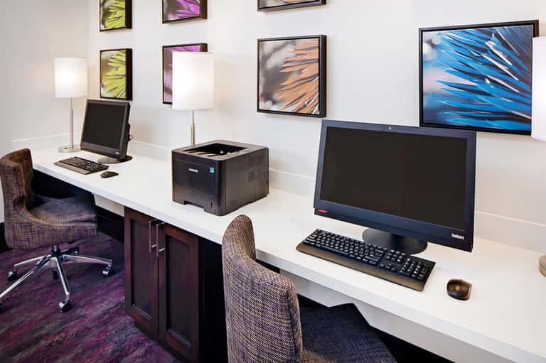 Business center with computer workstations and tropical wall art photography