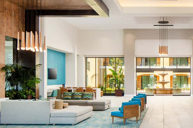 Modern hotel lobby with contemporary seating, pendant lighting, and natural light