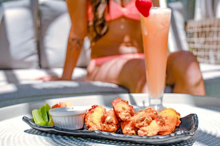 Fried appetizers with dipping sauce served poolside