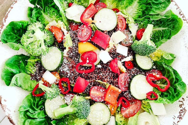 Colorful salad with lettuce, broccoli, tomatoes, peppers, cucumber, and feta cheese