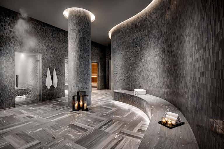 Modern spa area with rainfall columns, mosaic tile walls, and ambient lighting
