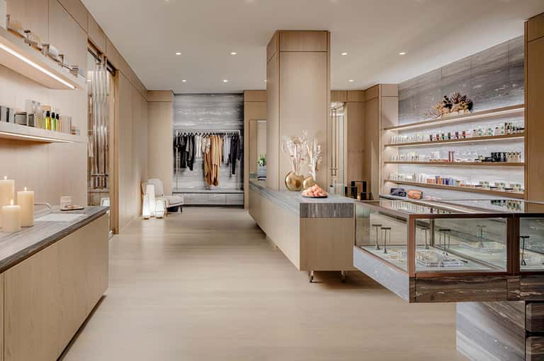 Luxury spa interior with wood cabinetry, shelving, mirrors, and boutique displays