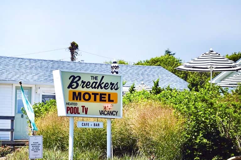 Vintage-style motel sign for The Breakers Motel with heated pool and cafe bar amenities listed